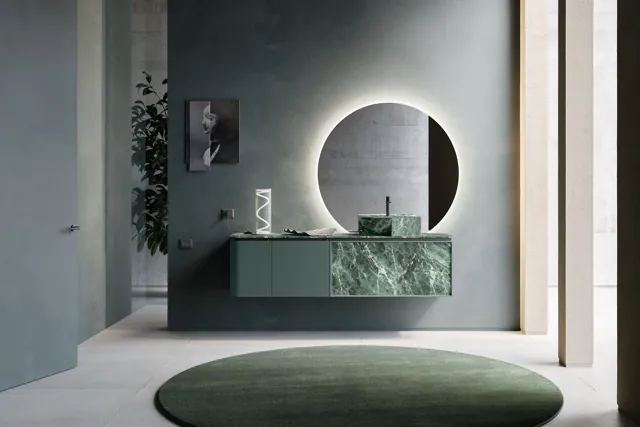Mobile DES Evolution sospeso verde con specchio circolare e tappeto dalle forme curve.